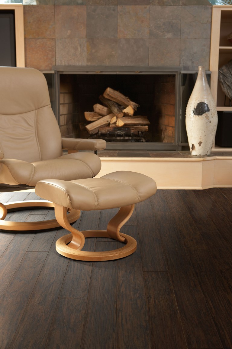 Dark flooring by fireplace and modern chair